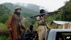 FILE - Pakistani Taliban patrol in then their stronghold of Shawal in Pakistani tribal region of South Waziristan, Aug. 5, 2012. The Pakistani Taliban, known as the TTP, have become emboldened in tribal areas along the border with Afghanistan. 