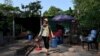 FILE - Resident Chea Srey Sar carries her belongings to a military truck at the Angkor Wat temple area in Siem Reap province, Cambodia, Jan. 16, 2023.
