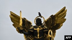 Seekor burung gagak duduk di atas patung Malaikat Pelindung Kyiv, Archangel Michael di Lapangan Kemerdekaan, 1 November 2023.