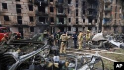 Sejumlah petugas tanggap darurat memeriksa kerusakan pada sebuah gedung apartemen di Kryvyi Rih, Ukraina, yang hancur dihantam oleh serangan roket Rusia, pada 13 Juni 2023. (Foto: AP/Andriy Dubchak)