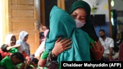 Seorang anak dengan cerebral palsy bersama ibunya mengikuti acara di pusat fisioterapi Yayasan Sahabat Difabel di Banda Aceh, Aceh, 6 Oktober 2021. (Foto: Chaideer Mahyuddin/AFP)