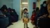 FILE - A child stands in a waiting room at a clinic run by the Swedish Committee for Afghanistan, in Wardak province, Afghanistan, Oct. 6, 2021. The SCA was forced to halt its activities last year, including services for new mothers and support programs for the disabled. 