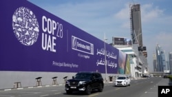 Sejumlah mobil berjalan melewati papan iklan COP28 yang dipasang di jalan tol Sheikh Zayed di Dubai, Uni Emirat Arab, pada 27 November 2023. (Foto: AP/Kamran Jebreili)