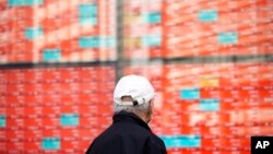 File - A person walks in front of an electronic stock board showing Japan's Nikkei 225 index on Jan. 22, 2024, in Tokyo.