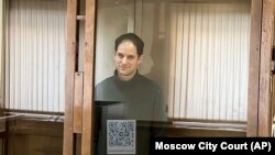 Wartawan Wall Street Journal, Evan Gershkovich, berdiri di dalam kurungan kaca di ruang persidangan di Pengadilan Kota Moskow, pada 20 Februari 2024. (Foto: Moscow City Court via AP)