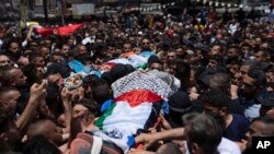 Para pelayat Palestina membawa jenazah Hamza Maqbool, 32, belakang dan Khayri Shaheen, 34, saat pemakaman mereka di kota Nablus, Tepi Barat, Jumat, 7 Juli 2023. (Foto: AP)