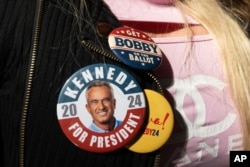 A supporter wears campaign buttons during an event for independent presidential candidate Robert F. Kennedy Jr., March 30, 2024, in Los Angeles.