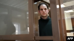 Amerčki novinar Evan Gerškovič, uhapšen pod optužbama za špijunažu, gleda iz kaveza za optuženike pre početka saslušanja po njegovoj žalbi, tokom predkaznenog pritvora, u Moskovskom gradskom sudu, 20. februara 2024. (Foto: AFP/Natalia Kolesnikova)
