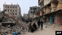 People sit in front of the Al-Faruk mosque, levelled by Israeli bombardment in Rafah in the southern Gaza Strip on Feb. 25, 2024, amid continuing battles between Israel and the Palestinian militant group Hamas.