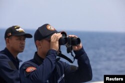 Personel Garda Pantai Filipina melihat melalui teropong di Laut China Selatan, 4 Oktober 2023. (Foto: Reuters)