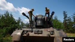 Ukrainian servicemen speak to each other atop a Gepard self-propelled anti-aircraft gun during their combat shift, amid Russia's attack on Ukraine, in Kyiv region, Ukraine June 30, 2023.