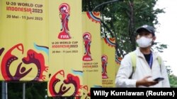 Seorang pria berjalan melewati spanduk FIFA U20 World Cup di luar kantor PSSI, setelah Indonesia dicoret sebagai tuan rumah Piala Dunia U20 akibat protes anti-Israel, di Jakarta, 30 Maret 2018. 2023. (Foto: REUTERS/Willy Kurniawan)