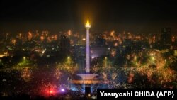 Perayaan tahun baru sekitar Monumen Nasional Indonesia (MONAS) di Jakarta pada 1 Januari 2024. LBH Jakarta meminta Presiden Jokowi mencabut Surat Presiden tentang penugasan wakil pemerintah untuk membahas RUU Daerah Khusus Jakarta (Foto: Yasuyoshi CHIBA/AFP)