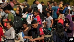 FILE - Migrants wait to be processed by U.S. Customs and Border Protection after they crossed the Rio Grande and entered the U.S. from Mexico, Oct. 19, 2023, in Eagle Pass, Texas.