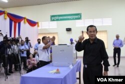 លោក ហ៊ុន សែន ប្រធានគណបក្ស​ប្រជាជន​កម្ពុជា ​លើក​ដៃចង្អុល​បង្ហាញអ្នកសារព័ត៌មាន​ បន្ទាប់​ពី​ដាក់សន្លឹក​ឆ្នោត​ចូល​ធុង នៅក្នុងមណ្ឌល​បោះឆ្នោត​ខេត្ត​កណ្តាល កាល​ពីថ្ងៃទី២៥ ខែកុម្ភៈ ឆ្នាំ​២០២៤។ (លាស់ លីបលីប/វីអូអេ)