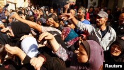 Palestinians queue as they wait to buy bread from a bakery, amid shortages of food supplies and fuel, as the conflict between Israel and Palestinian Islamist group Hamas continues, in Khan Younis in the southern Gaza, Nov. 17, 2023.