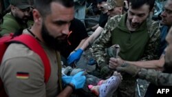 Rescuers and volunteers carry a person from the rubble after Russian missile strike hit a restaurant and several houses in Kramatorsk, Ukraine, June 27, 2023.