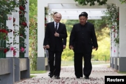 19일 북한을 방문 중인 블라디미르 푸틴 러시아 대통령과 김정은 북한 국무위원장이 평양 해방기념탑에서의 헌화식에 앞서 함께 걷고 있다.