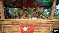 FILE - Members of the Mandalay People's Defense Forces stand guard at their base camp in the forest near Namhsan Township in Myanmar's northern Shan State, Dec. 9, 2023.