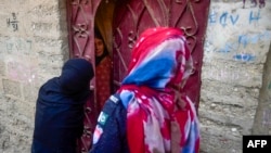 FILE - Police personnel interrogate an Afghan refugee during a search operation to identify alleged illegal immigrants, on the outskirts of Karachi, Pakistan, Nov. 17, 2023.