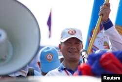 FILE - General Hun Manet, son of Cambodia's Prime Minister Hun Sen holds a party flag as he attends a kickoff of an election campaign rally for the upcoming national election in Phnom Penh, Cambodia, July 1, 2023.