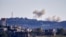 FILE - A picture taken from from the southern Lebanese village of Tayr Harfa, near the border with Israel shows smoke billowing near an Israeli outpost from rockets fired by Hezbollah on Dec. 15, 2023. 