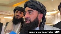 FILE - Zabihullah Mujahid, chief Taliban spokesperson, talks with reporters in Doha, Qatar, June 30, 2024.