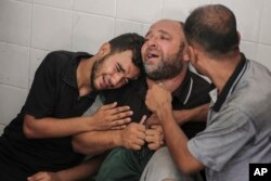 Ayah Mohammad al-Habil menangis bersama kerabatnya setelah putranya terbunuh bersama pamannya, Abdul Muti al-Habil, di Deir al Balah, Jalur Gaza, 14 Juni 2024. (Foto: AP)