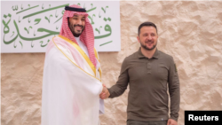 Putra Mahkota Mohammed bin Salman berjabat tangan dengan Presiden Ukraina Volodymyr Zelenskyy di Jeddah, Arab Saudi, 19 Mei 2023. RI mengirim Kuasa Usaha Ad Interim KBRI di Riyadh untuk ikut konferensi guna mencari solusi damai Ukraina di Jeddah. (Foto: Ilustrasi via REUTERS)