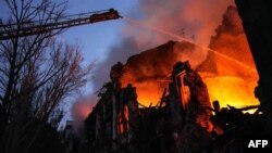 Tim penyelamat memadamkan api di gedung tempat tinggal yang hancur setelah serangan rudal di pusat Mykolaiv. (Foto: via AFP)