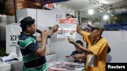 Petugas pemilu menghitung suara di TPS setelah pemungutan suara pemilu ditutup di Jakarta, 14 Februari 2024. (REUTERS/Ajeng Dinar Ulfiana)