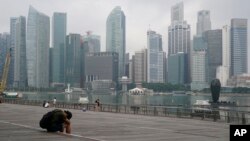 Seorang pria sedang tidur siang saat kawasan pusat bisnis diselimuti kabut di Singapura, pada 23 September 2019. (Foto: AP)