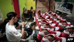 A staff of a small shoe manufacturer makes their new products as they make an introductory video to be posted on social media in Bogor, West Java, Sept. 27, 2023.