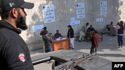 Seorang petugas keamanan berjaga saat para kandidat menerima surat pencalonan mereka untuk pemilihan umum mendatang di kantor KPU di Lahore pada 20 Desember 2023. (Foto: AFP)