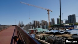 一名男子坐在北京一处建筑工地旁。（2023年4月18日）