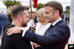 法国总统马克龙在法国奥马哈海滩欢迎乌克兰总统泽连斯基出席诺曼底登陆80周年纪念活动。（2024年6月6日）
