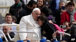 2023年3月29日，教宗方济各在梵蒂冈圣彼得广场的每周公开接见结束时拥抱一个孩子。（美联社照片）