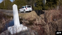 FILE - The marker of the US/Canada border at Roxham Road Feb. 26, 2017, in Champlain, NY.