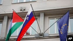 2024年5月30日，在斯洛文尼亚首都卢布尔雅那，一面巴勒斯坦旗帜飘扬在斯洛文尼亚国旗(中)和欧盟旗帜(右)旁边。(美联社照片)