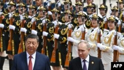 Presiden China Xi Jinping dan tamunya, Presiden Rusia Vladimir Putin, menghadiri upacara penyambutan kenegaraan di depan Aula Besar Rakyat di Lapangan Tiananmen di Beijing pada 16 Mei 2024. ( Sergei Bobylyov/Sputnik/via AFP)