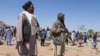 Pasukan kemanan Taliban berjaga di saat para warga mengebumikan korban serangan di masjid Syiah di distrik Guzara, provinsi Herat, pada 30 April 2024. (Foto: AFP/Mohsen Karimi)