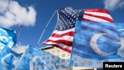 Bendera AS dan Uyghur berkibar dalam aksi protes mendukung komunitas Uyghur. Aksi berlangsung di Washington, pada 28 November 2022. (Foto: Reuters/Amanda Andrade-Rhoades)