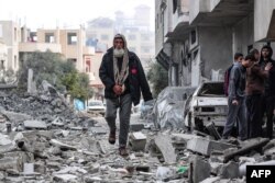 A man finds his way amid the rubble of the Palestinian al-Atrash family home after it was destroyed in an Israeli strike in Deir el-Balah in the central Gaza Strip, March 13, 2024.