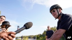 拜登总统2023年5月14日在特拉华州里霍博斯海滩的戈登斯池塘州立公园骑自行车时与记者讲话。（美联社照片）