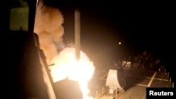 资料照片：美国海军“阿利·伯克号”导弹驱逐舰从红海向“伊斯兰国”目标发射一枚战斧式巡航导弹。(2014年9月23日)