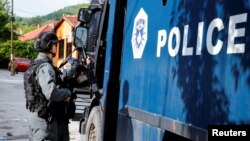 Kosovski policajac ispred zgrade opštine Zvečan, jun 2023.
