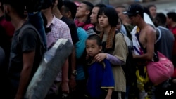 FILE - Chinese migrants line up to take a boat to Lajas Blancas after walking across the Darien Gap in Bajo Chiquito, Panama, May 7, 2023.