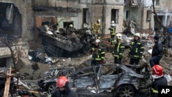 Petugas pemadam kebakaran berupaya memadamkan api di gedung apartemen yang hancur setelah serangan Rusia di Kyiv, Ukraina, Selasa, 2 Januari 2024. (AP/Efrem Lukatsky)