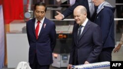 Presiden Joko Widodo dan Kanselir Jerman Olaf Scholz melihat komponen di stan Siemens, saat mereka berkunjung ke pameran teknologi Hanover.
