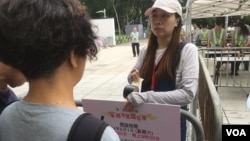 A carnival worker tells members of the public they cannot enter the restricted area until later in the day, at Victoria Park, Hong Kong, June 4, 2024. (Cindy Sui/VOA)